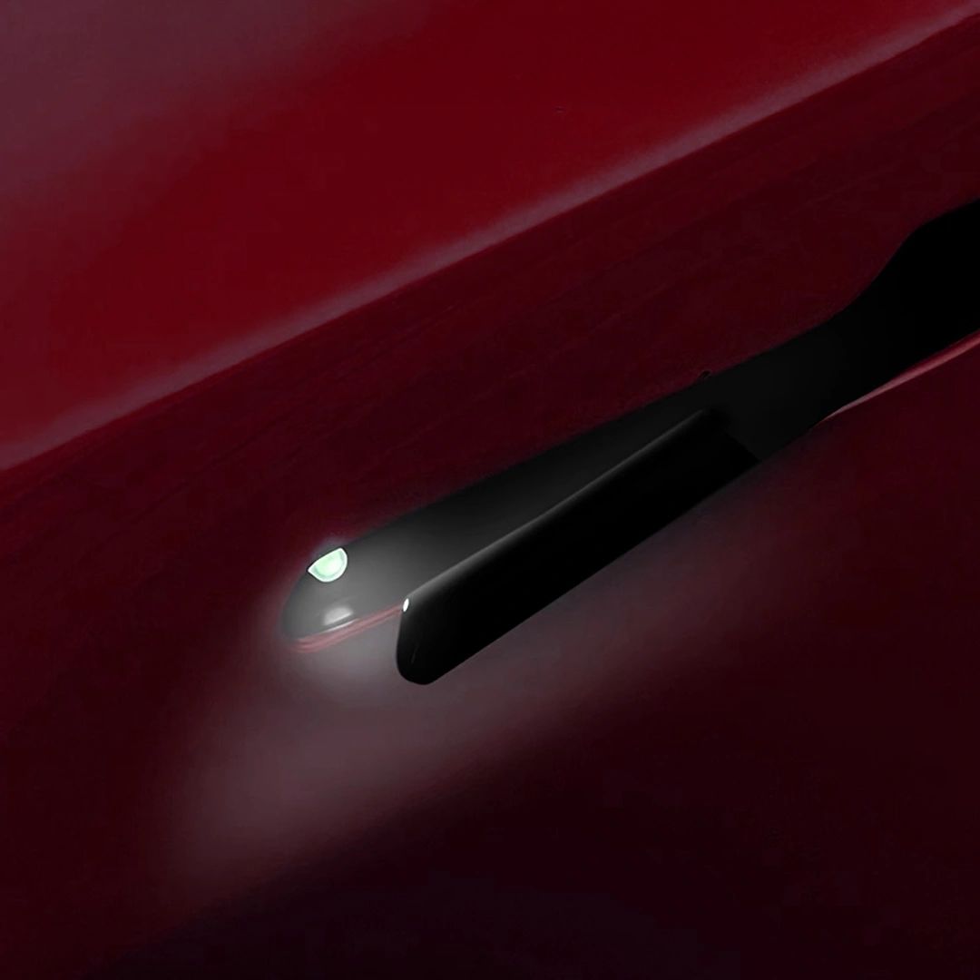 An illuminated presenting door handle on a Tesla
