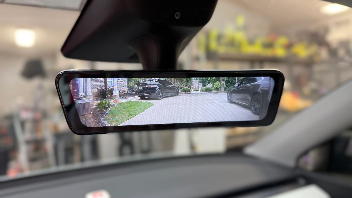A streaming rearview mirror in a Tesla showing the live rear camera feed